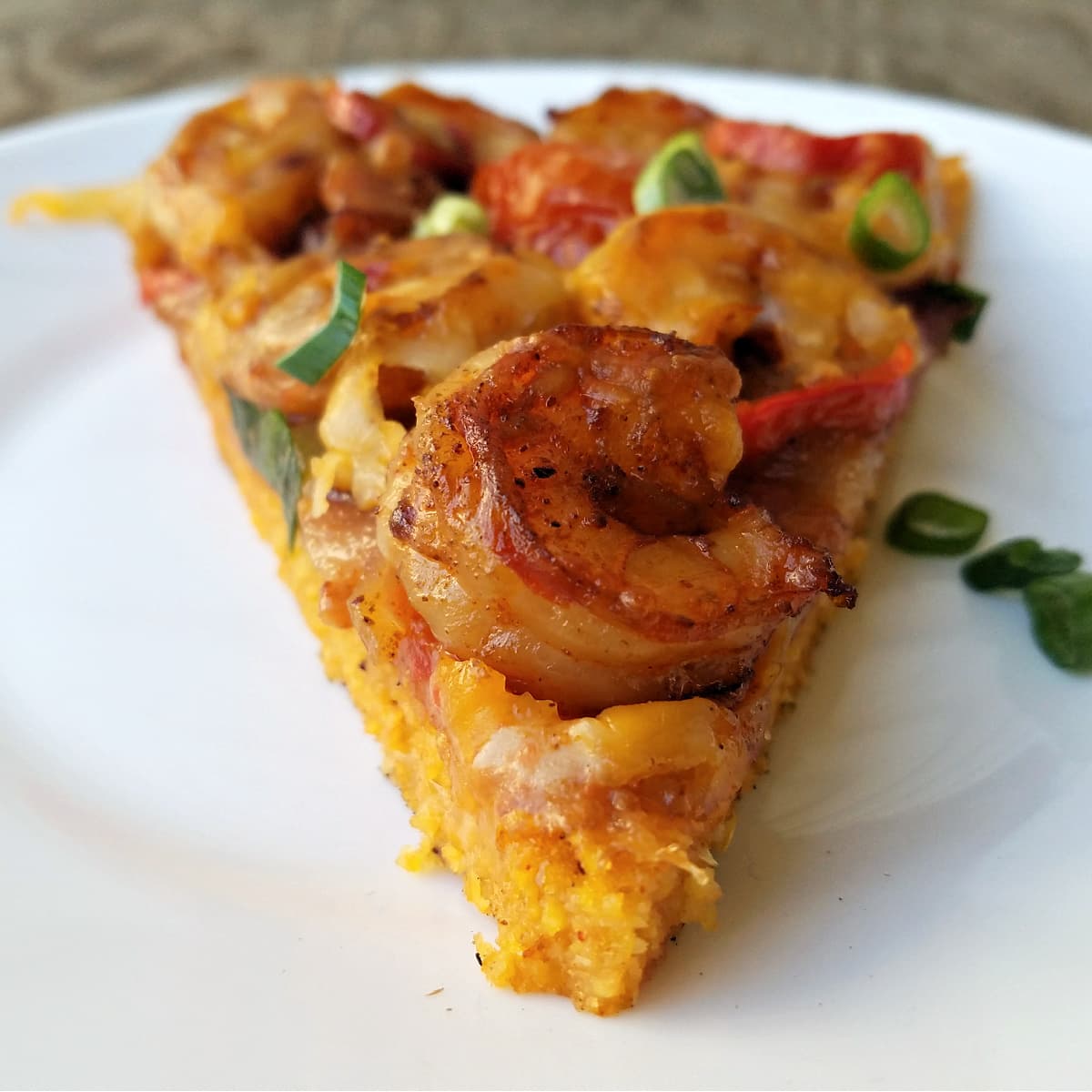 Single slice of Shrimp & Grits pizza, point facing forward. 