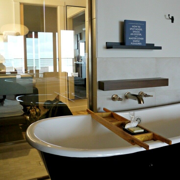 Cast iron soaking tub with wooden soap ladder and brass fittings. 