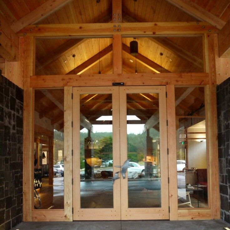 Wood beam and glass entrance doors to Headlands Resort. Large metal geese in flight as handles. 