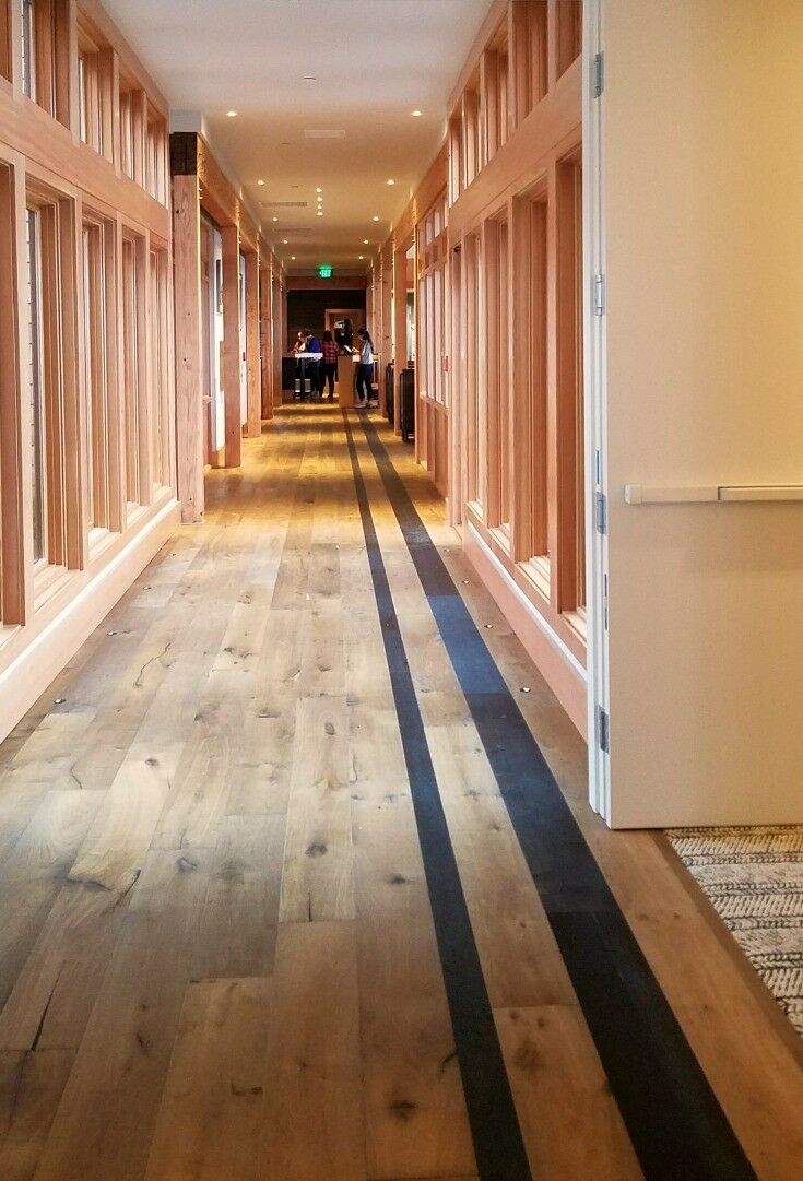 Looking down long hallway lined with wood beams and glass windows. 