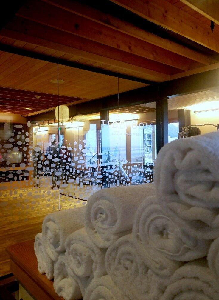 Rolled white towels stacked outside glass spa doors. 