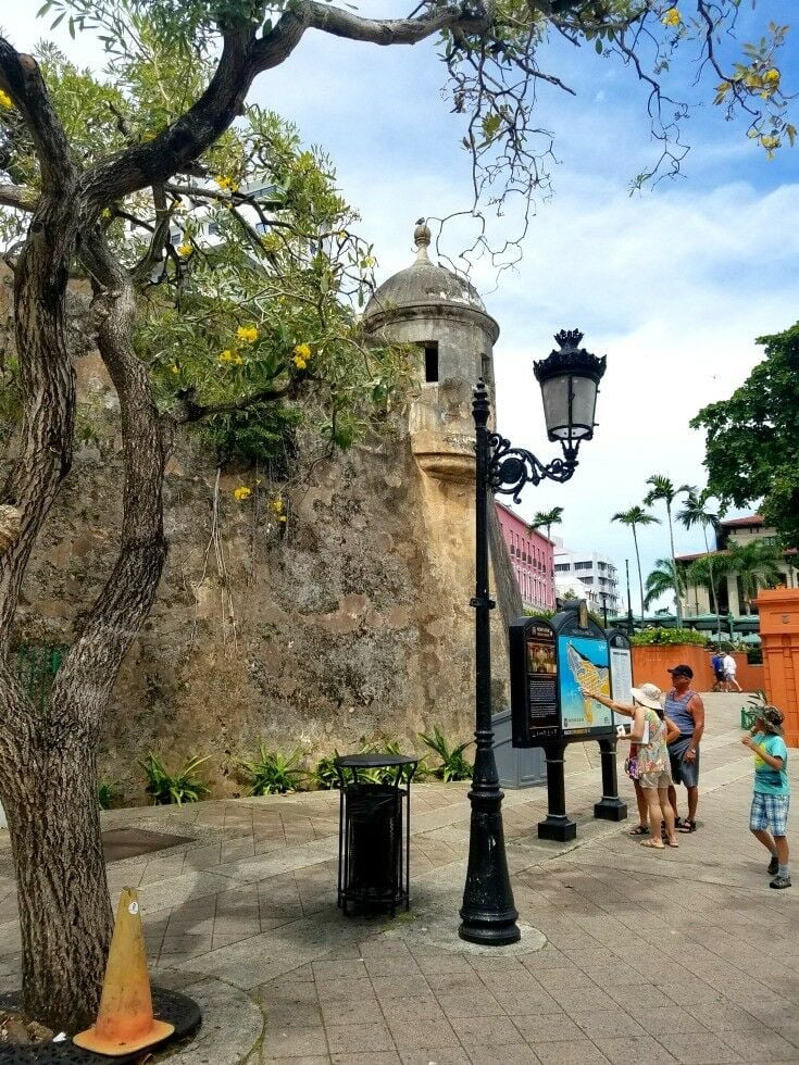 People looking and pointing at a large public map. 