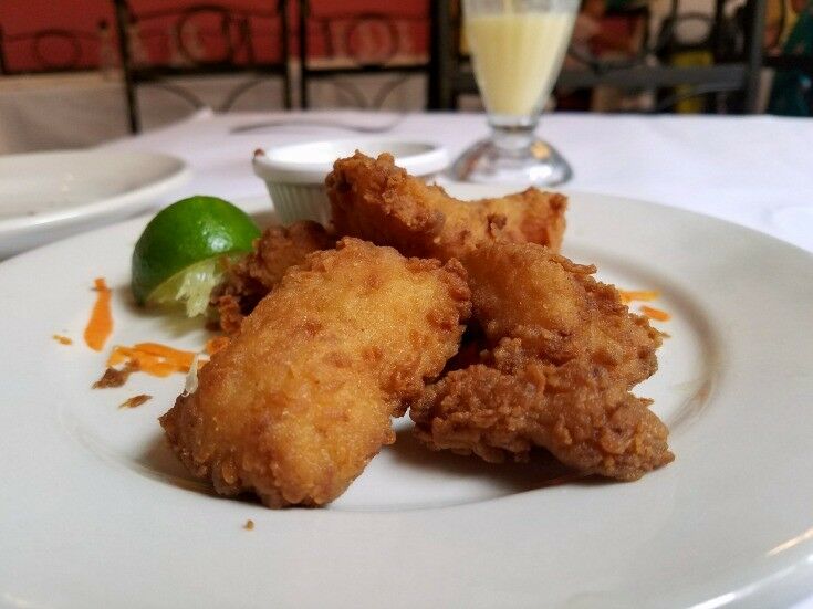  Grouper fritters (lightly breaded with coconut), on a plate with a slice of lime. 