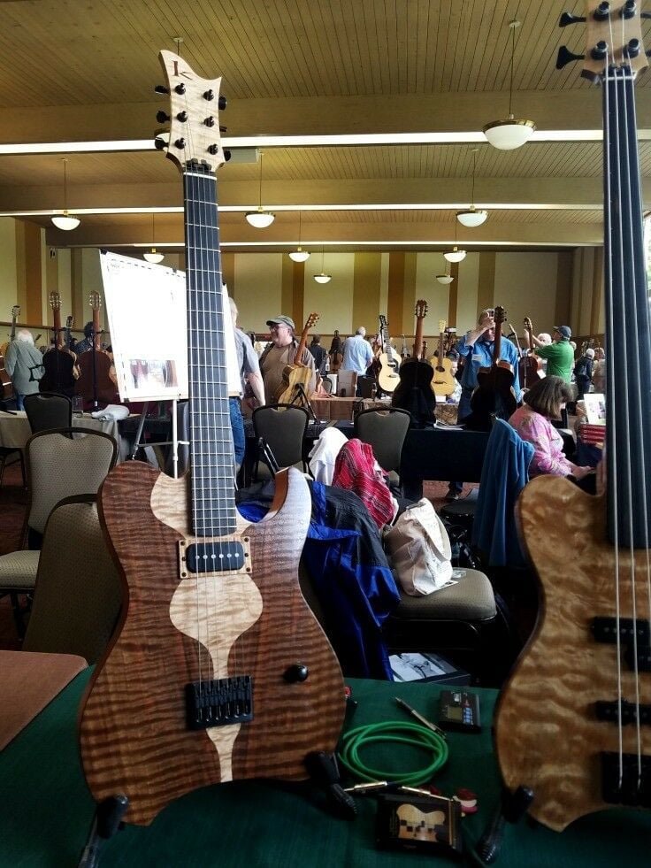 Wooden electric guitars, with crowd in background. 