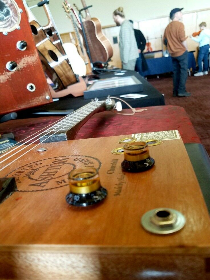 Display of electric cigar-box guitars by Del Puckett. 