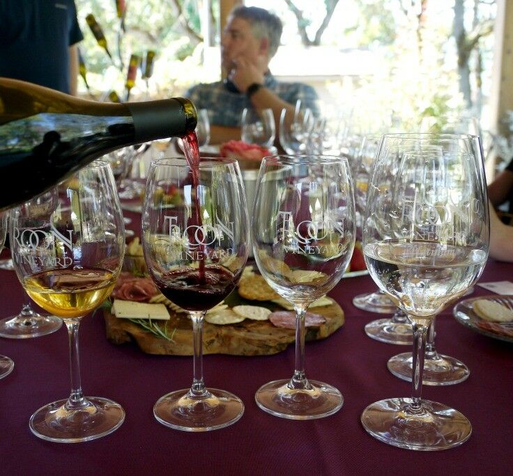 Wine being poured into tasting glasses. 