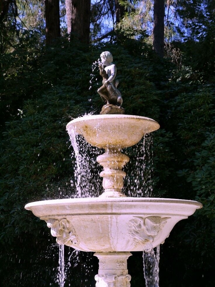 Fountain with boy holding duck on top.