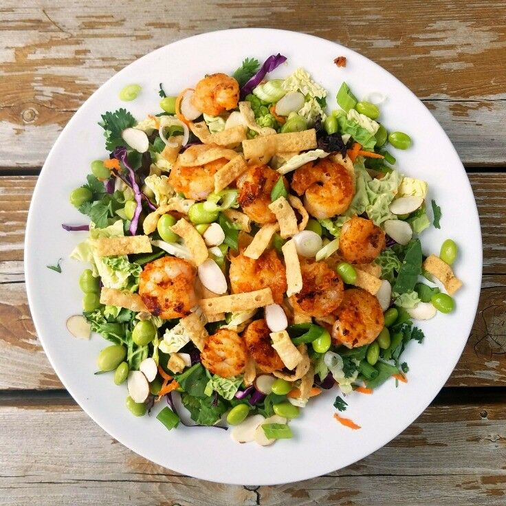 Overhead shot of Thai Shrimp Salad with Spicy Peanut Sauce on white plate. 