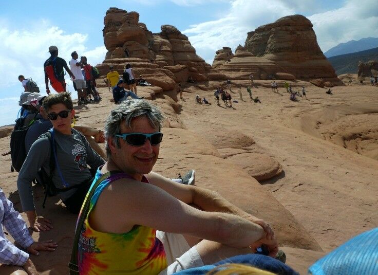 Rick resting on the sandstone plateau above the Delicate Arch. 