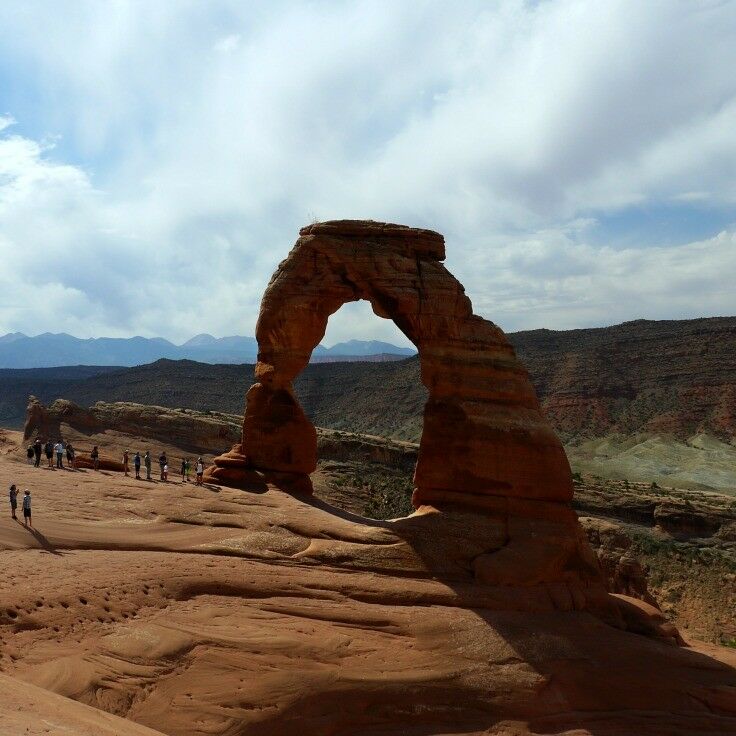 Arriving at the Delicate Arch, there are number of people near the bse of the arch. They help underscore its scale.