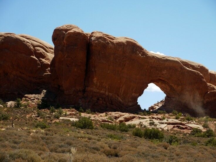 A large sanstone formation with a round hole running through it. 