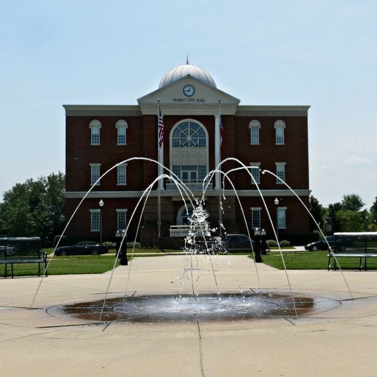 Tupelo City Hall in background. Fountain/splash pad in foreground. 