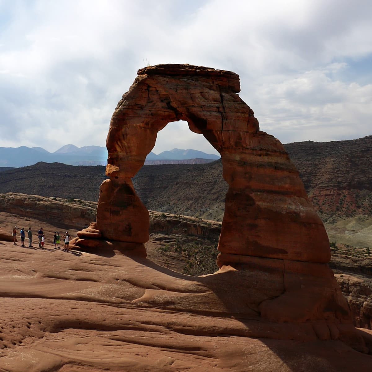 Delicate arch in the morning sun. Hikers at the base. 