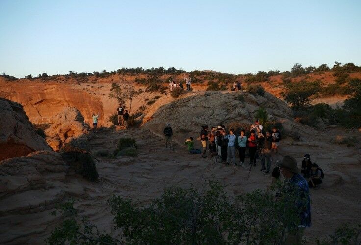 Group of people with cameras taking pictures of the sunrise. 