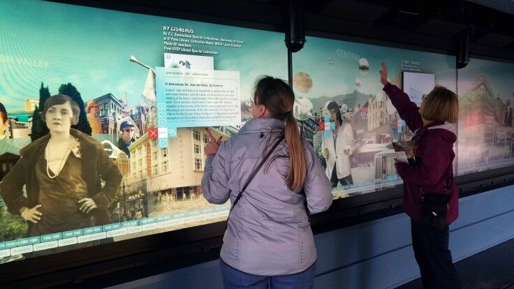 Women experimenting with a digital wall. 