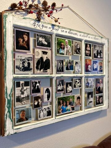 Two old window frames hung on wall next to one another; panels filled with matted photos.