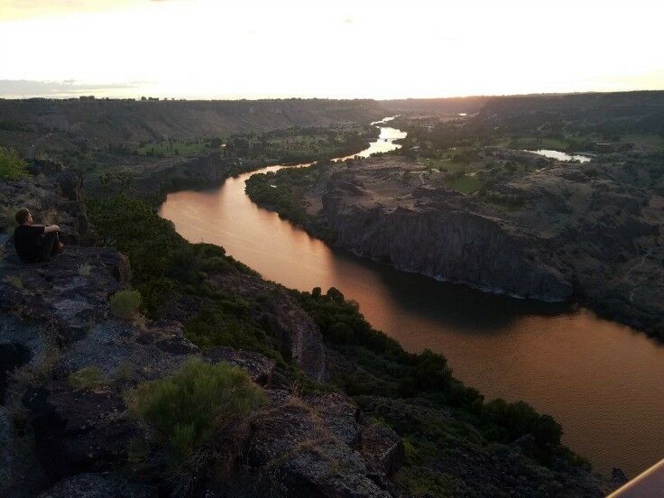 View of the Snake River at sunset from Perrine Bridge. The water reflects like liquid copper.