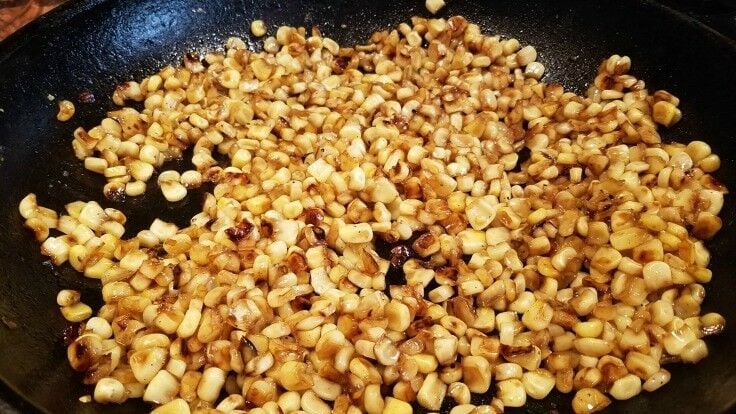 Corn frying in a cast iron skillet. 