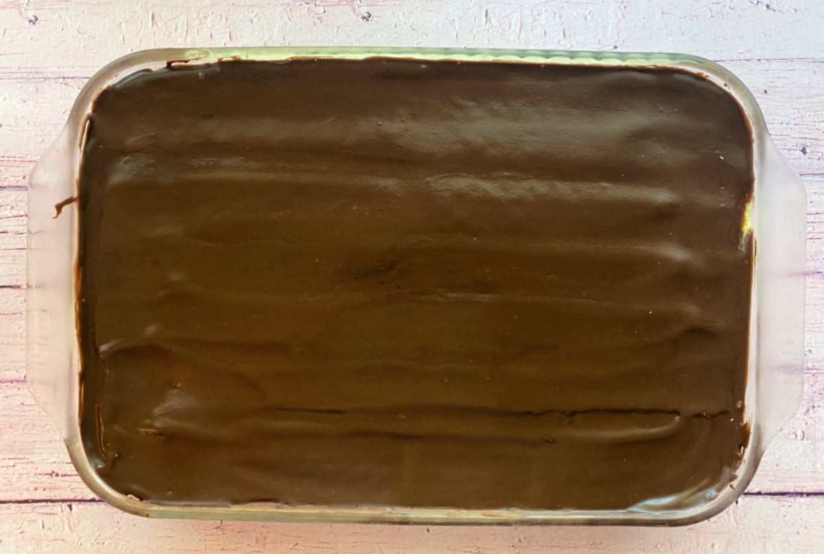 Top-down view of frosted eclair cake in glass baking dish.