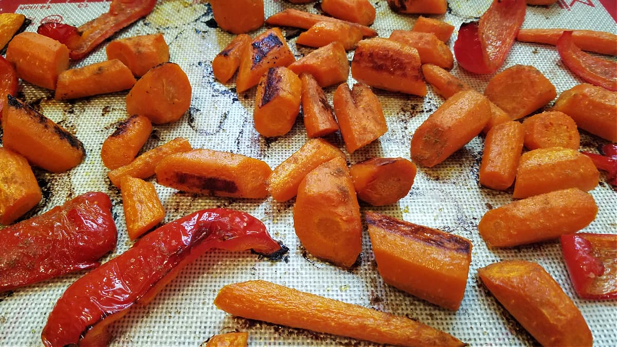 Roasted carrots and peppers on a baking sheet.