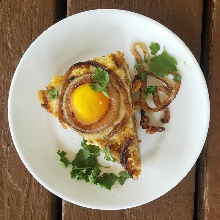 Slice of cornbread and egg casserole on plate. 