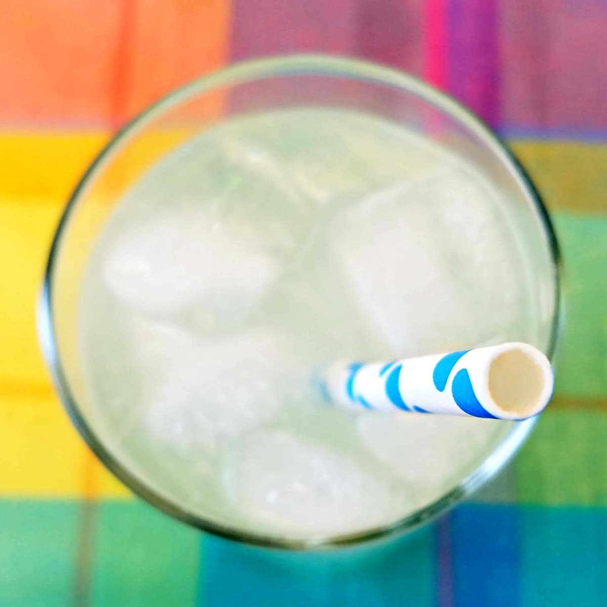 Overhead shot directly downinto a glass of lemonade, with a blue polka-dot straw coming up toward the viewer. 