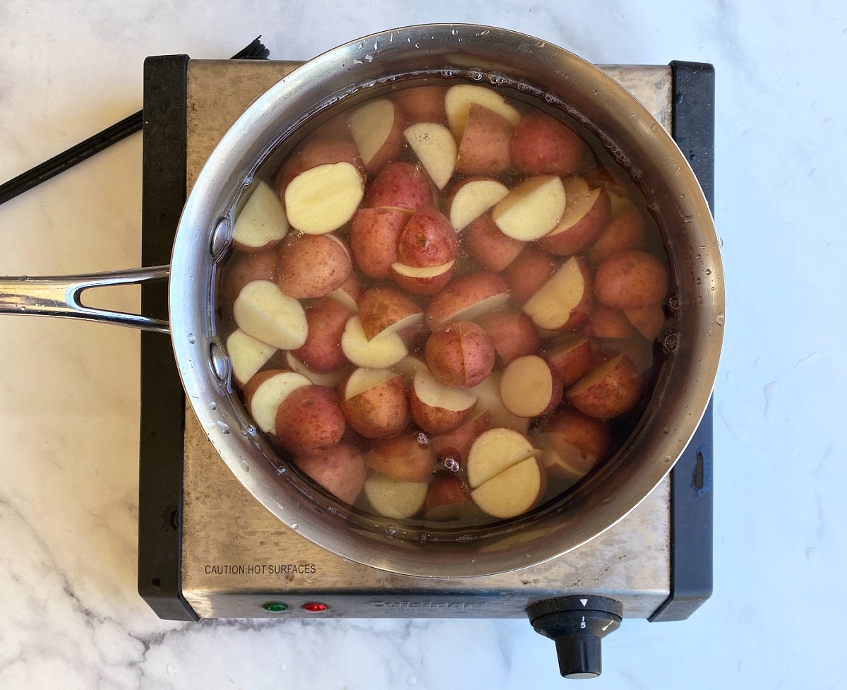 Cut potatoes into ½- to ¾-inch cubes and put them into a medium saucepan. (Leave skins on.) Add enough water to cover the tops of the potato cubes. Cover and boil about 15 minutes, or until tender but still firm.