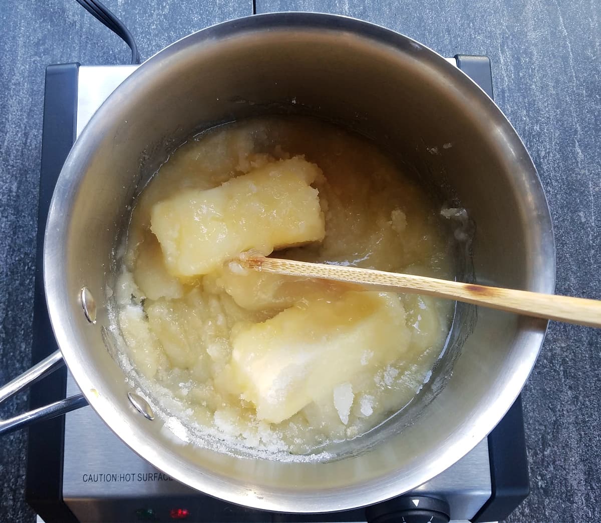 Overhead shot of butter, sugar, and corn syrup melting together in stockpot. 