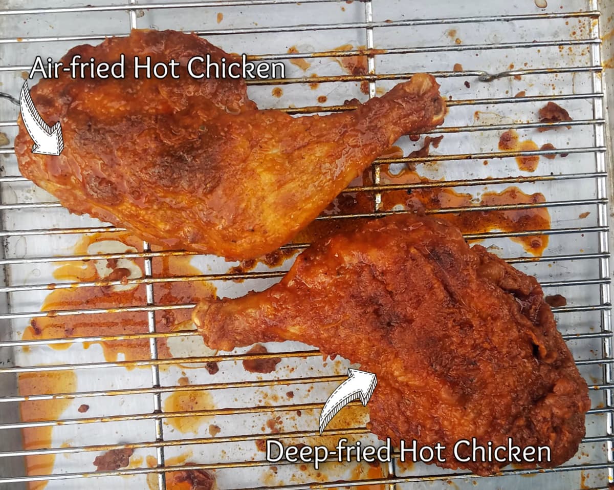 two fried chicken quarters on a rack, coated with sauce.