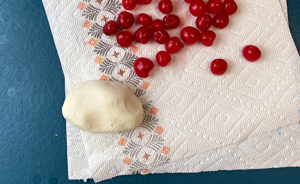 Mixed fondant and maraschino cherries on a paper towel, ready to wrap.