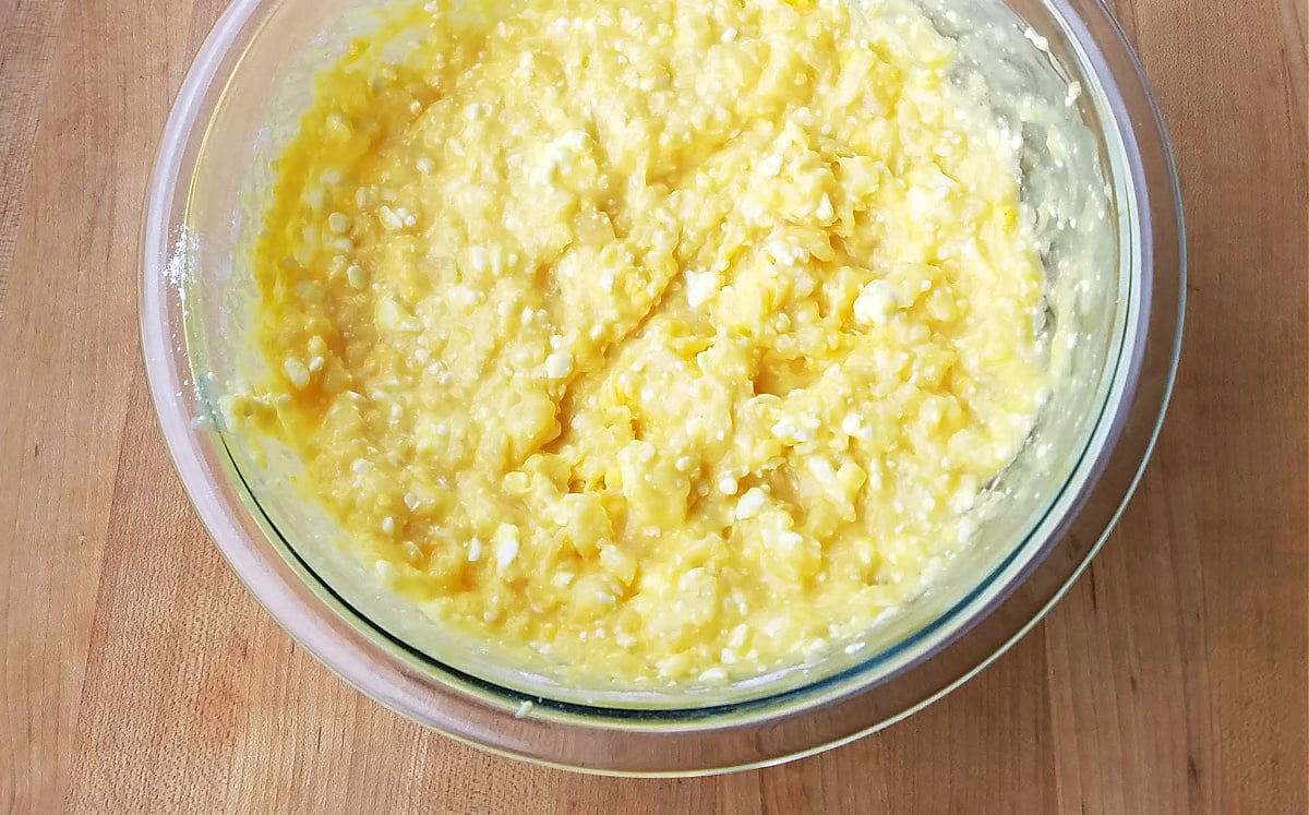 Thick yellow mixture in a glass mixing bowl.