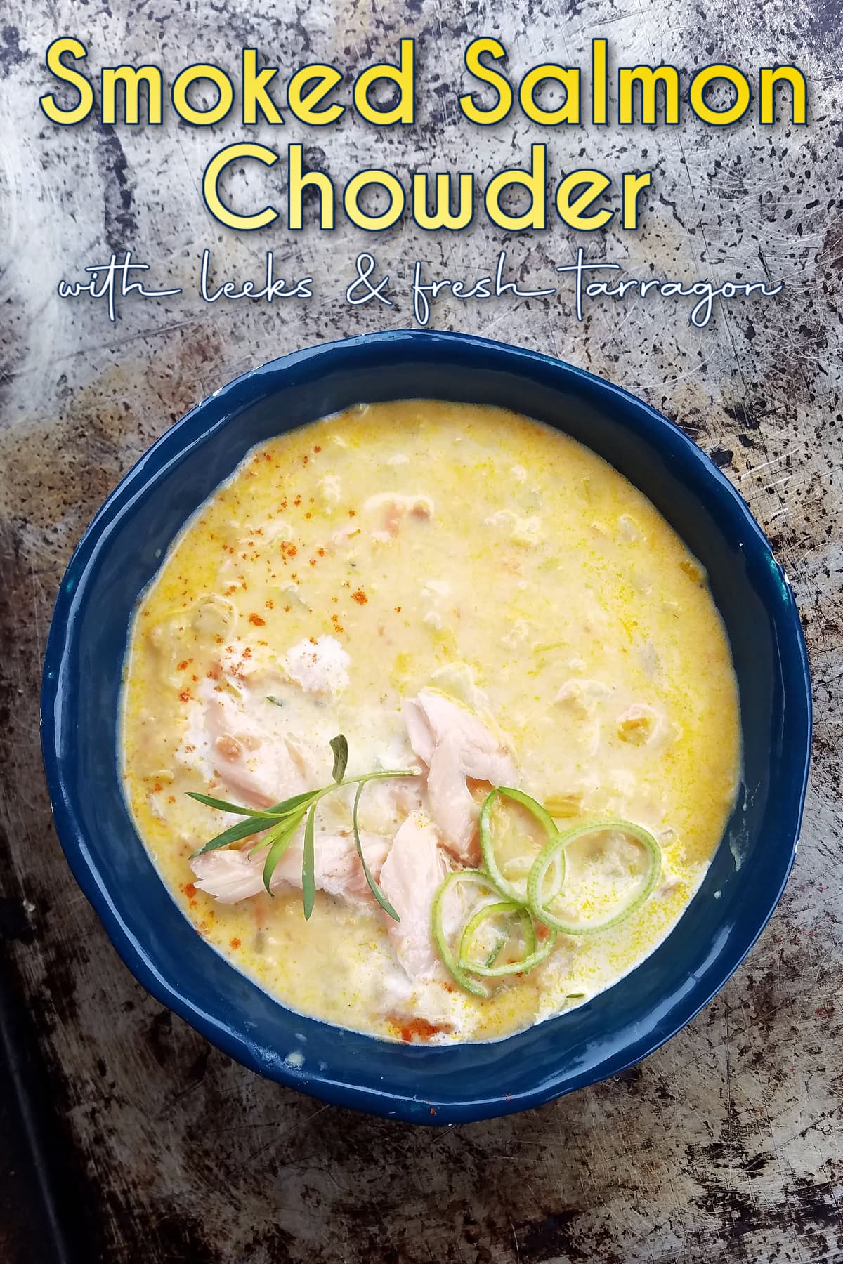 Bowl of salmon chowder, garnished with flaked smoked salmon, leek rings, and a sprig of fresh tarragon. Pin text overlay reads: Smoked Salmon Chowder with leeks and fresh tarragon.