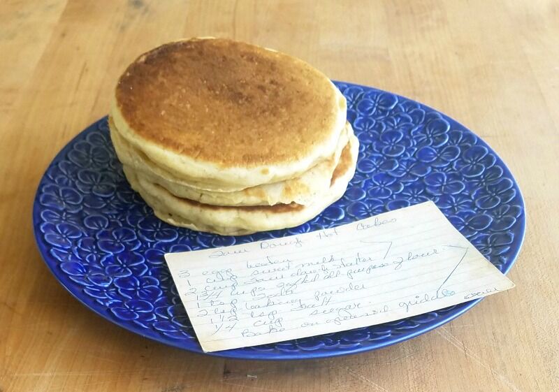 Mom's Sourdough Hot Cake Recipe on a plate with three stacked pancakes.