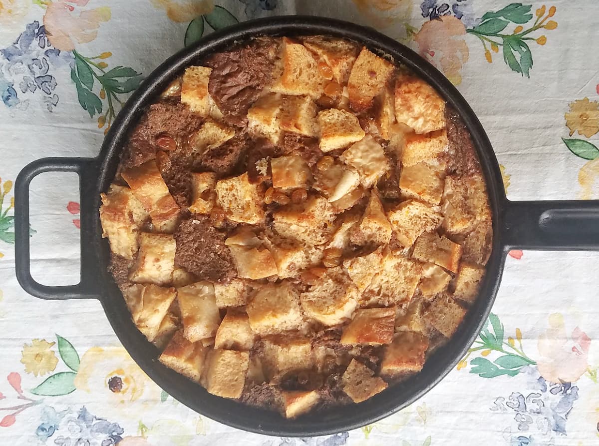 Baked, ungarnished bread pudding in a cast iron skillet.