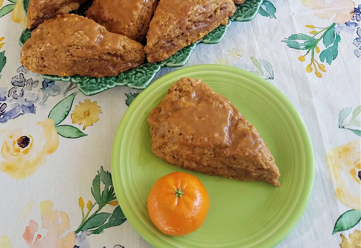 Pumpkin Spice Sourdough Scones, served with an orange on an old-fashioned plate. 