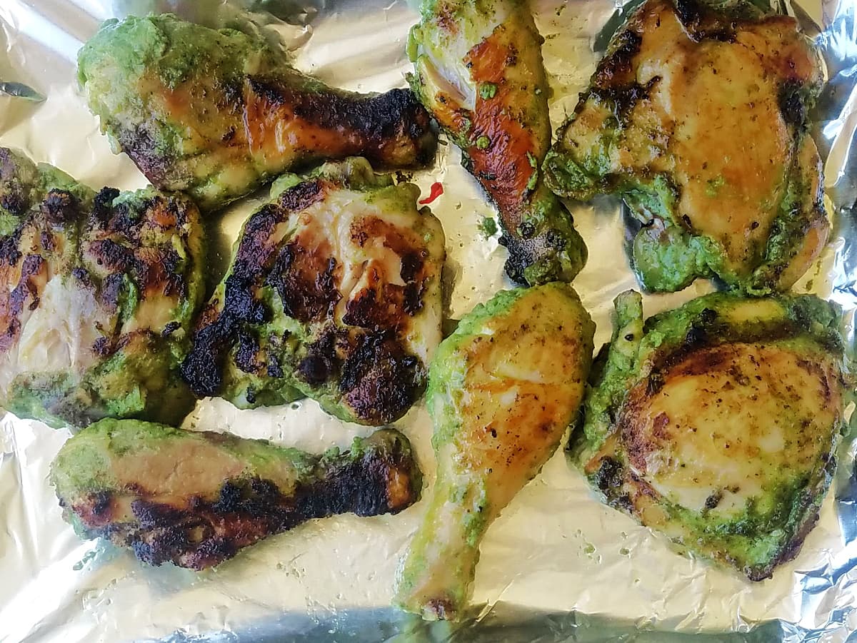 Seared chicken pieces resting on aluminum-covered baking tray. 