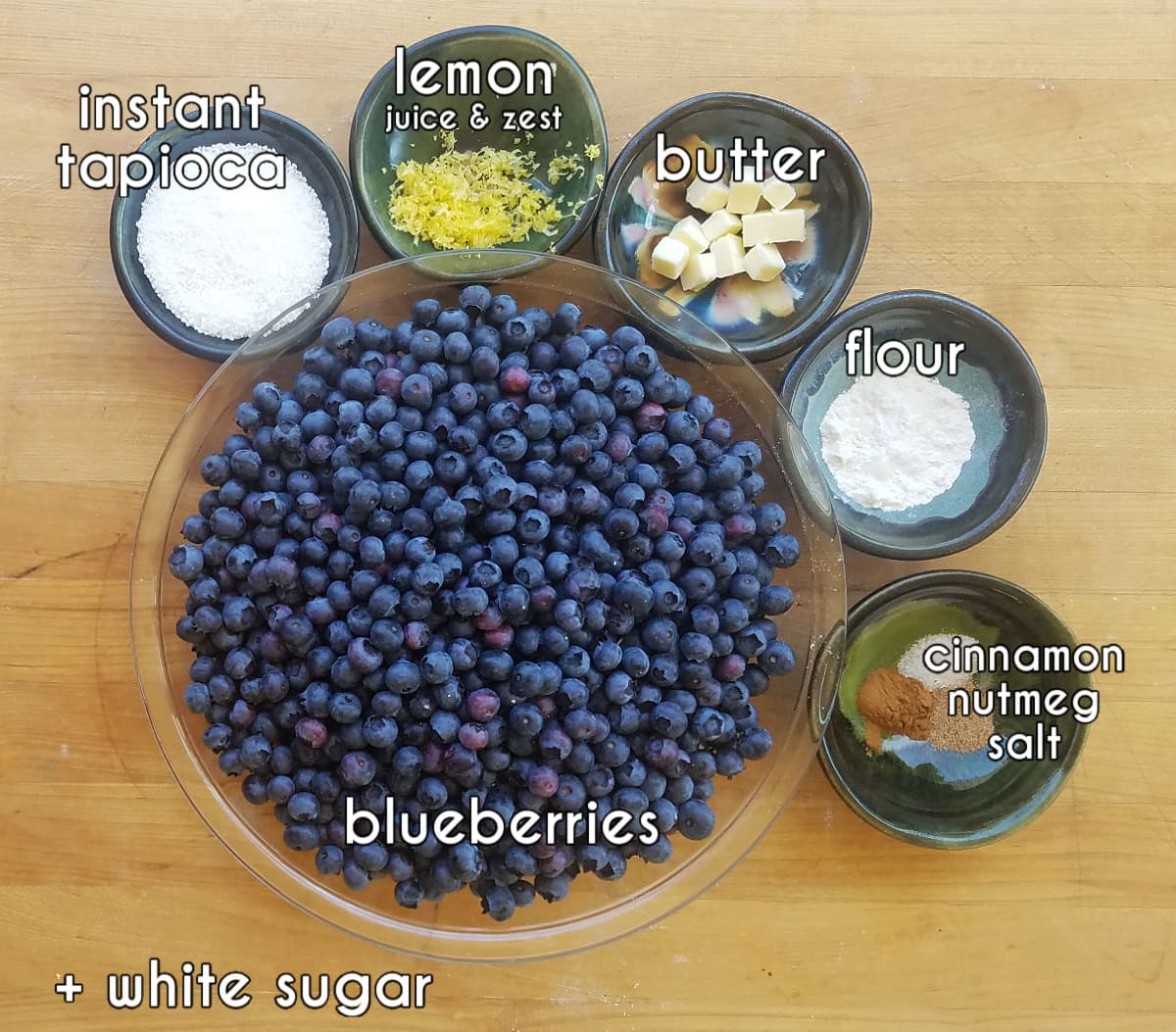Ingredients for blueberry pie filling: blueberries, tapioca, lemon, flour, spices, butter.