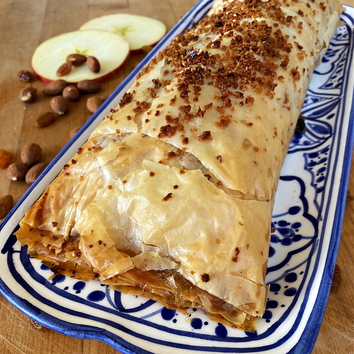 Close-up of a whole apple strudel on a long serving plate. 