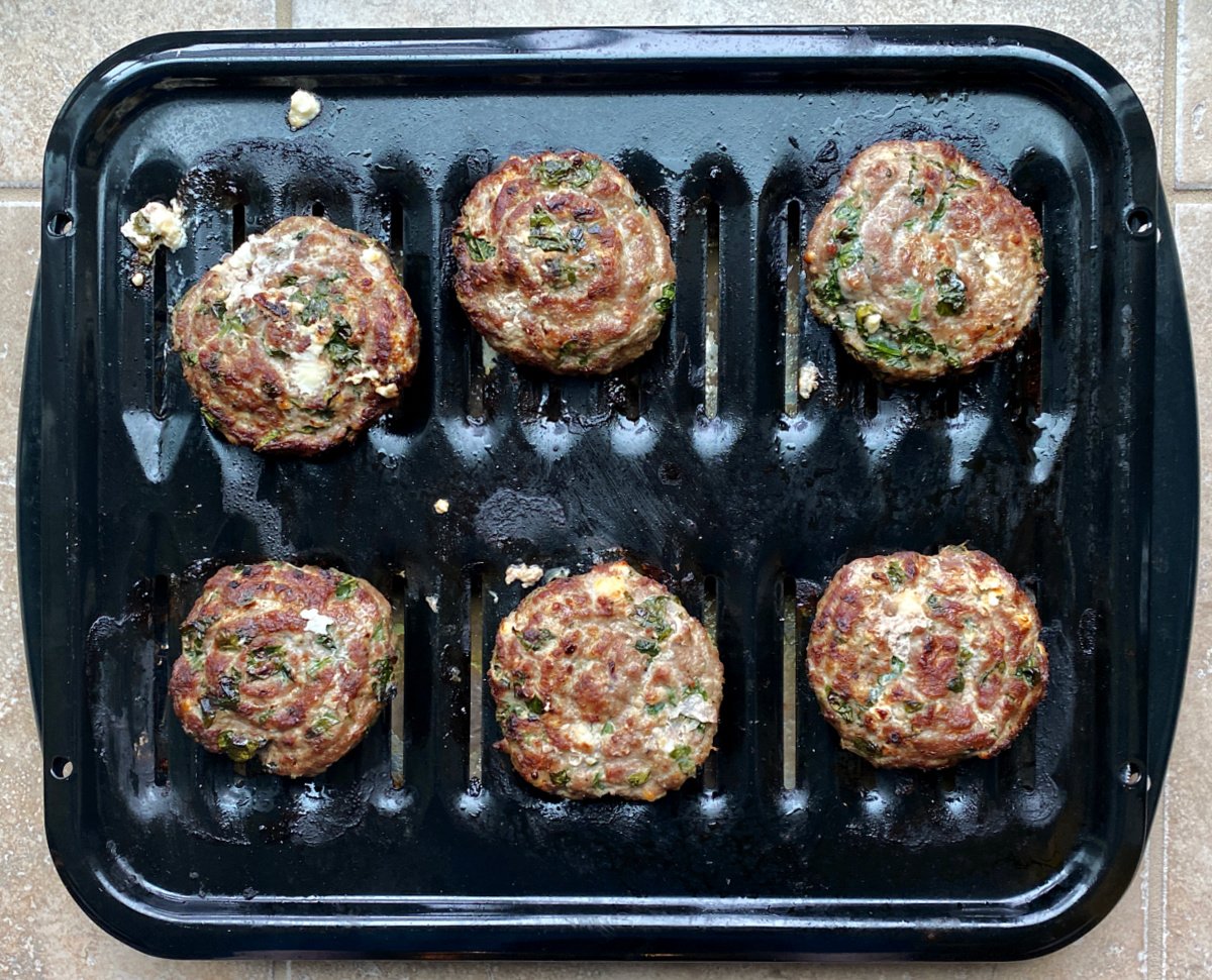 Cooked turkey burgers on broiling pan. 