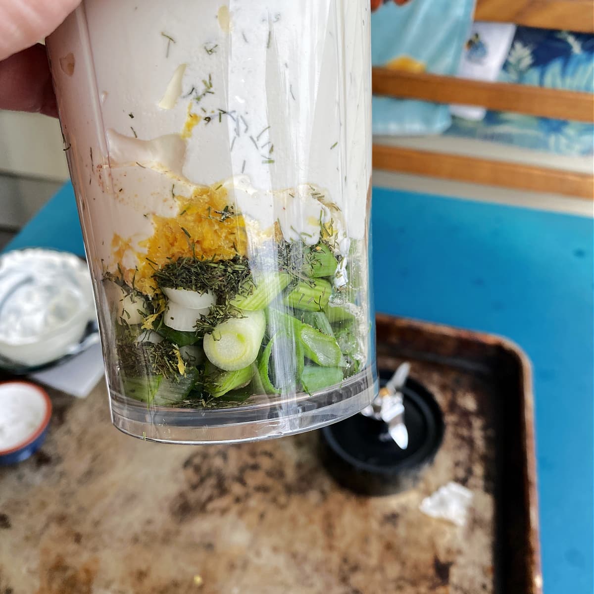 Closeup of ingredients layered in a beverage blender cup. 