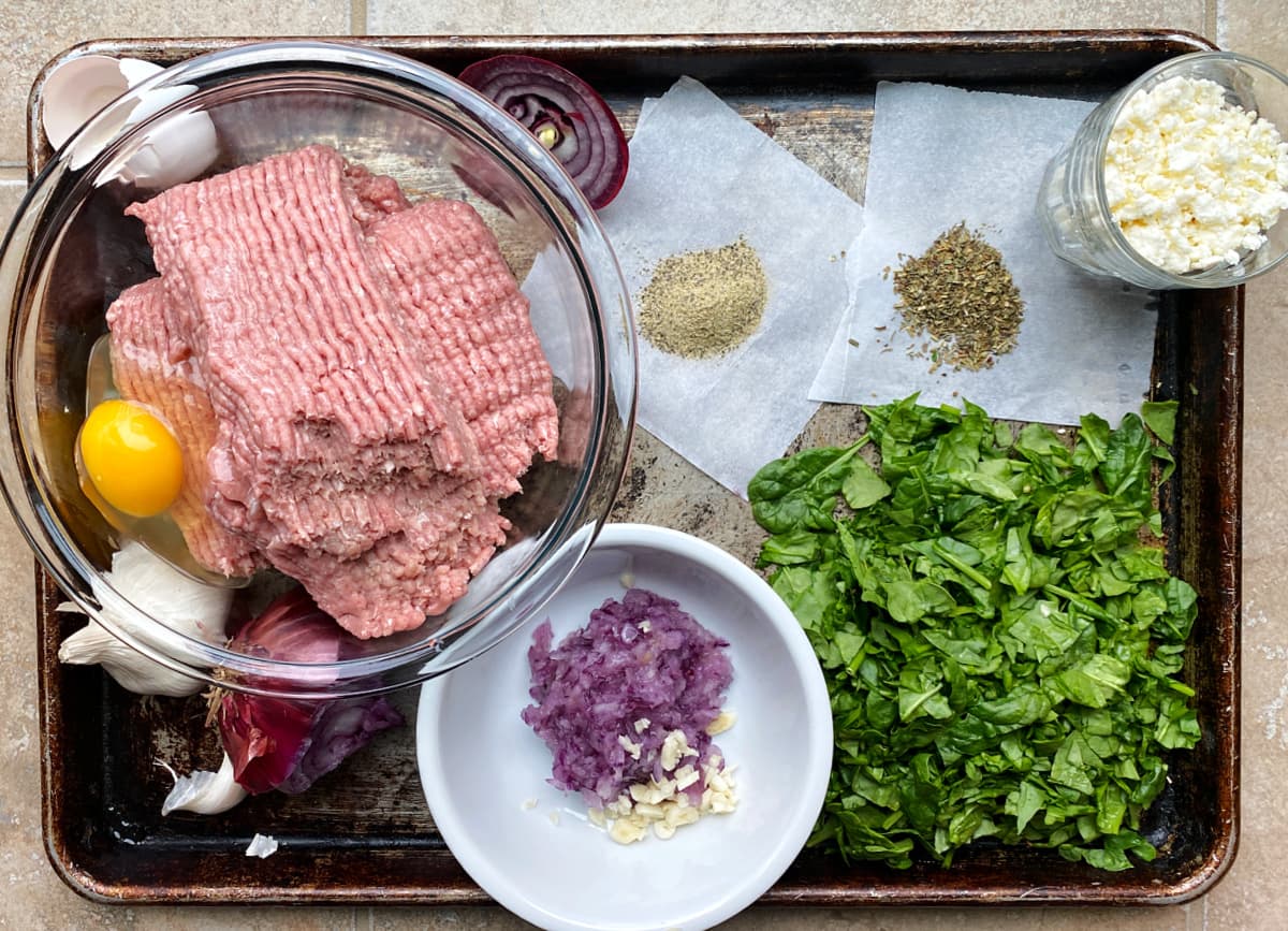 Turkey burger ingredients arranged on an old baking pan. 