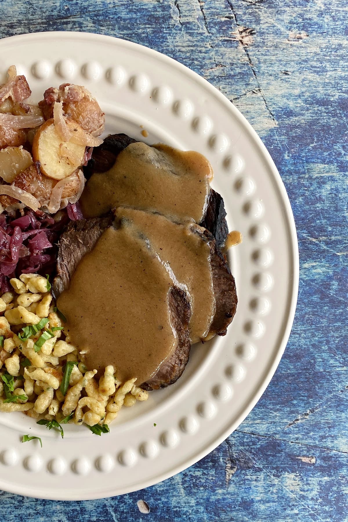 Sauerbraten plated with traditional Bavarian foods; Oktoberfest. 