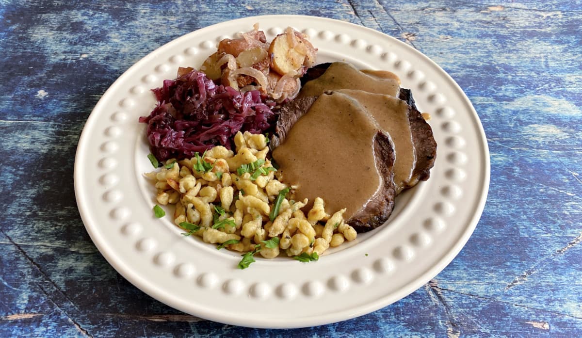 Sauerbraten plated with kartoffelsalat, rotkohl, and spaetzle; Oktoberfest. 