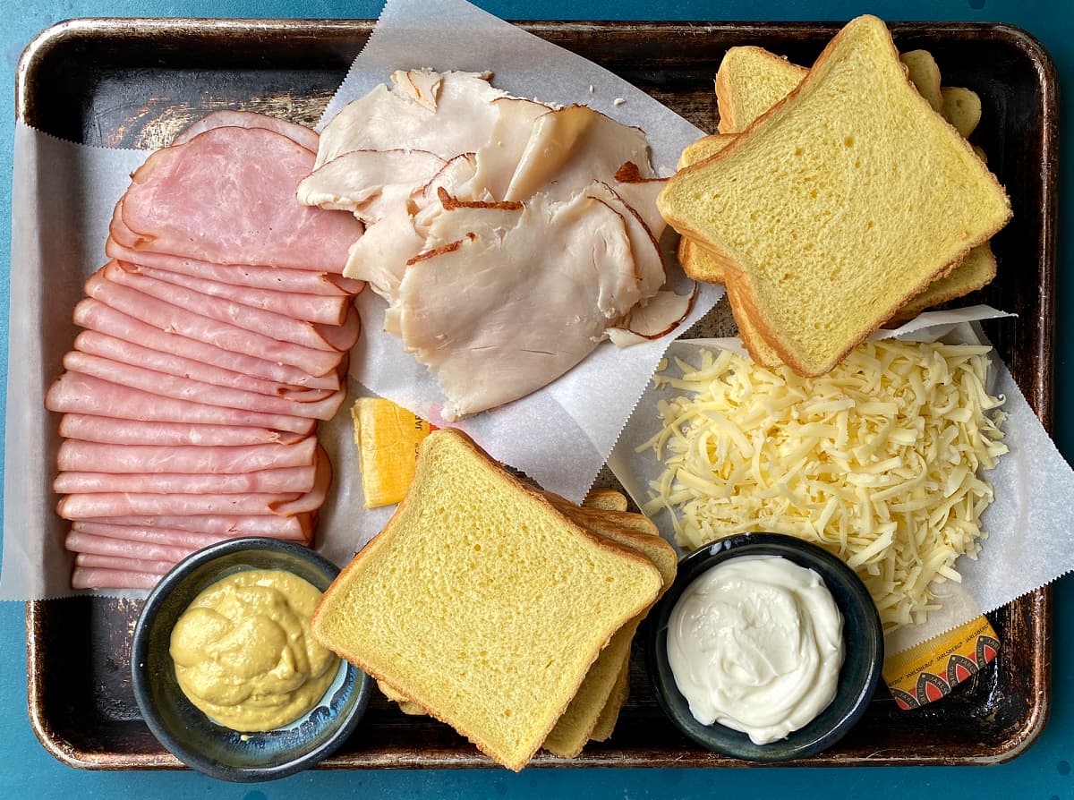 Ingredients for making Monte Cristo Sandwiches: bread, ham, turkey, swiss cheese, mayonnaise, mustard.