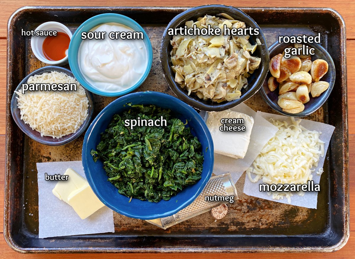 Spinach dip ingredients in various bowls, labeled. 
