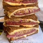 Stack of four Rueben sandwich halves, with melted swiss. Pin overlay reads: Classic Reuben Sandwich.