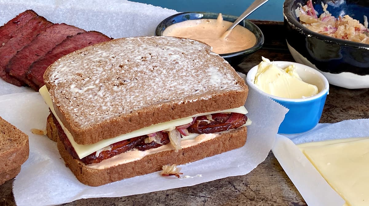 Untoasted Rueben sandwich, assembled and prepared with Russian dressing.