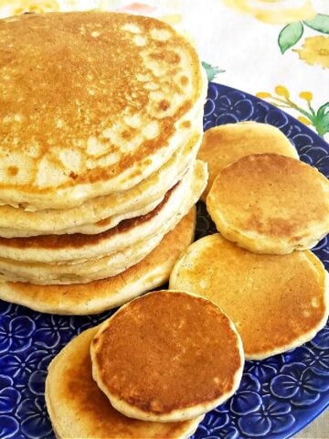 Stack of pancakes on a flowered blue plate.