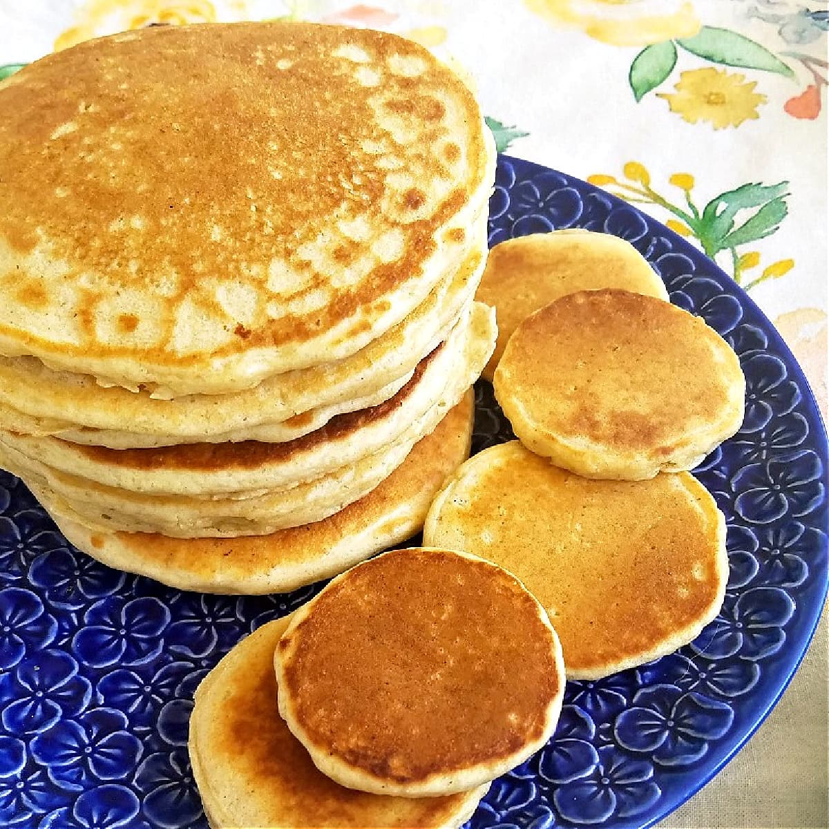 Stack of pancakes on a flowered blue plate. 