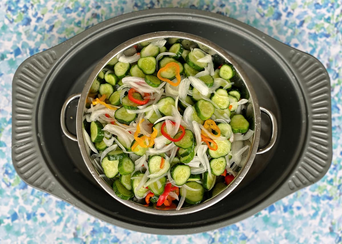 Prepared vegetables being drained in a large colander.
